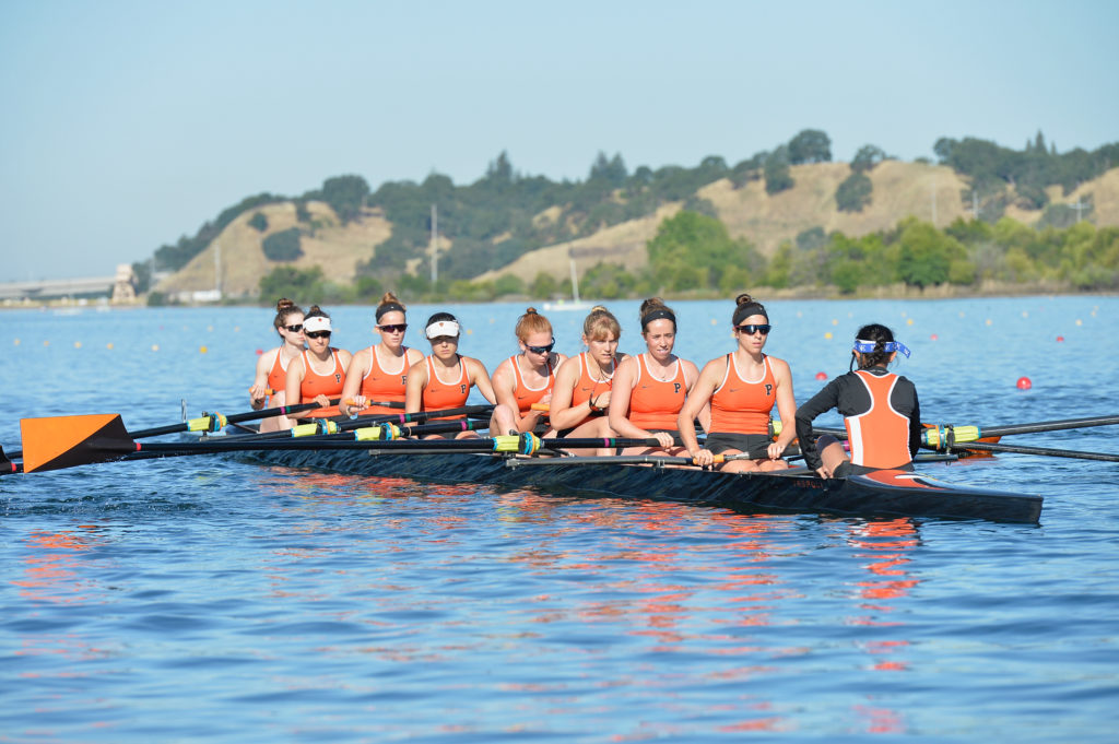 A group of people rowing a boat in a body of water