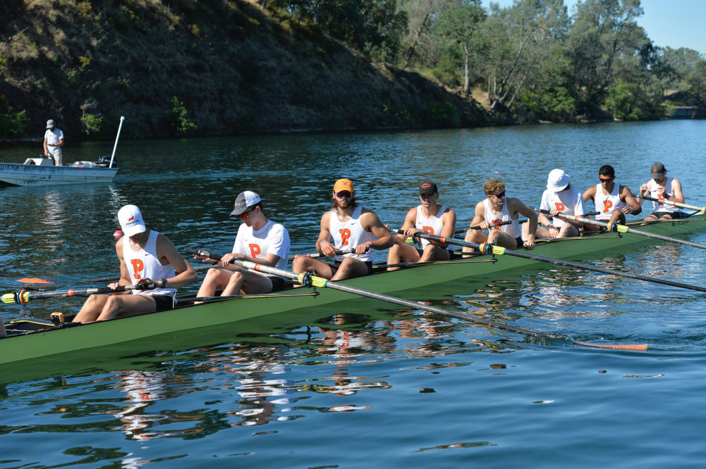 A group of people rowing a boat in the water