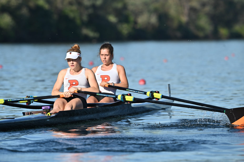 A group of people rowing a boat in a body of water