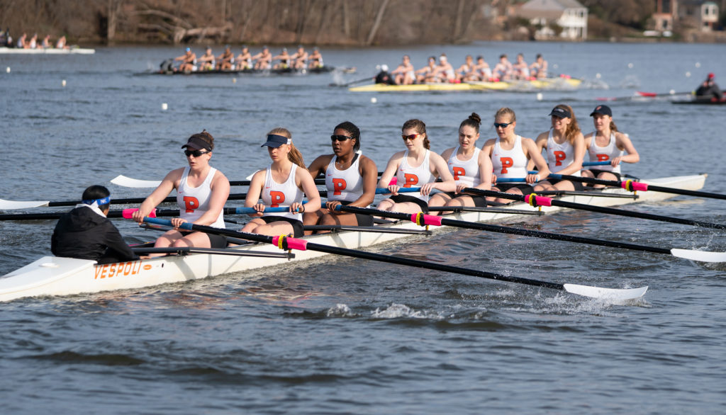 A group of people rowing a boat in a body of water