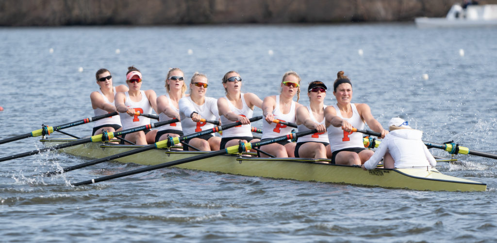 A group of people rowing a boat in a body of water