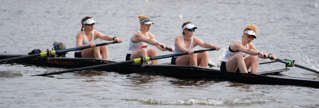 A group of people rowing a boat in the water