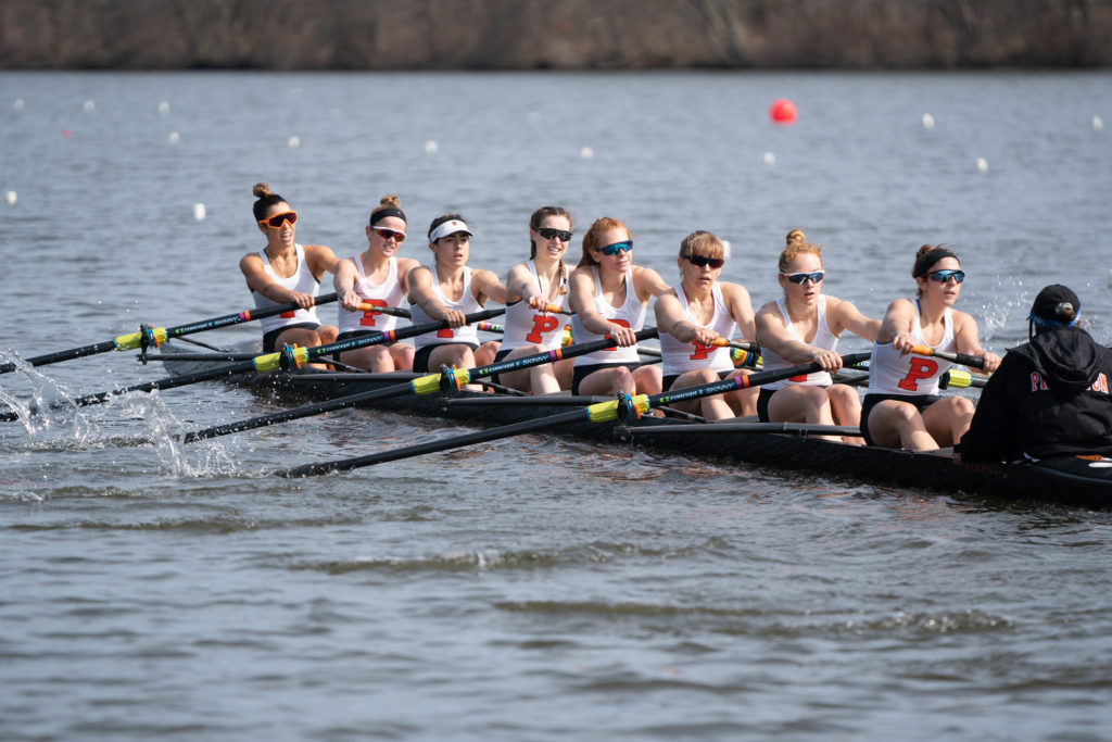 A group of people rowing a boat in the water