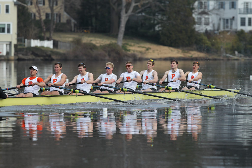 A group of people rowing a boat in the water