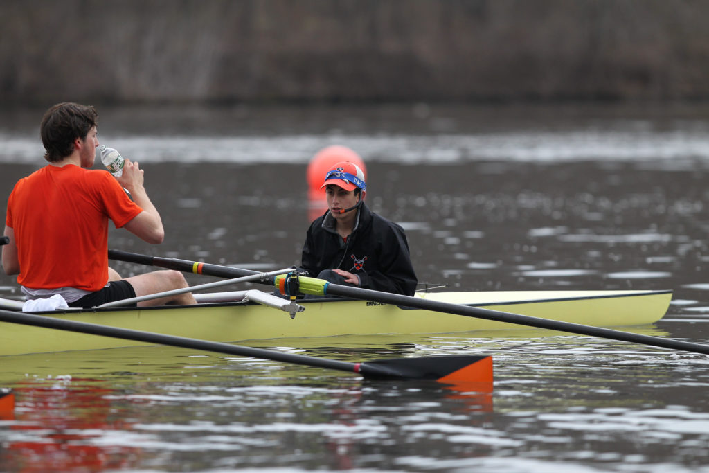 A group of people rowing a boat in the water