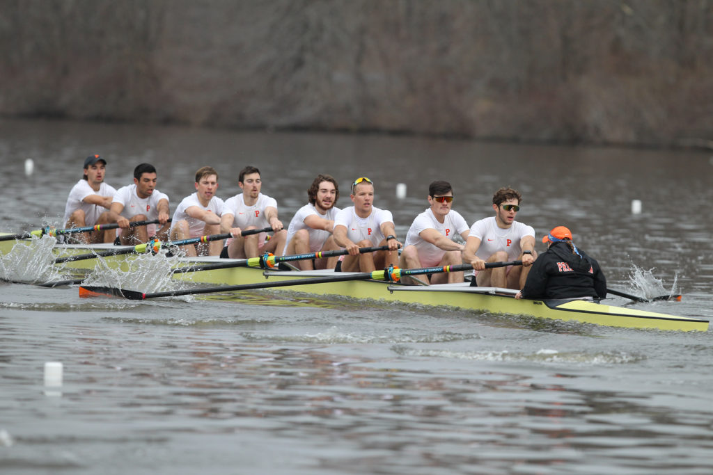 A group of people rowing a boat in the water