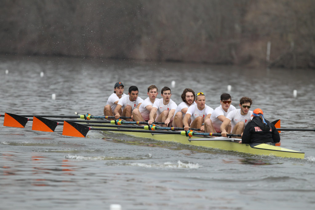 A group of people rowing a boat in a body of water