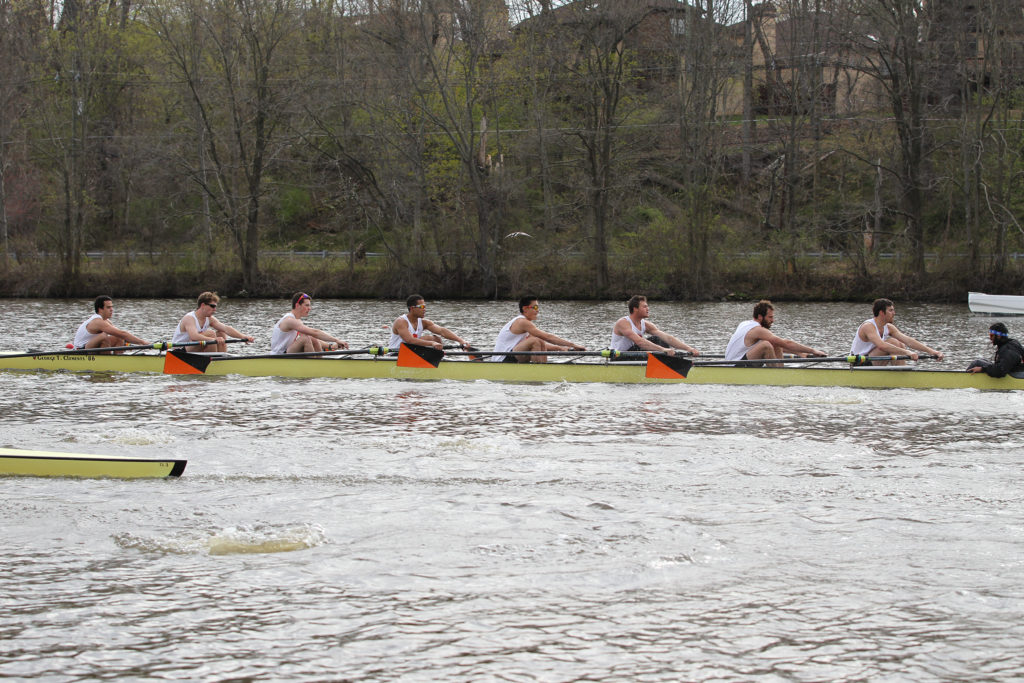 A group of people rowing a boat in the water