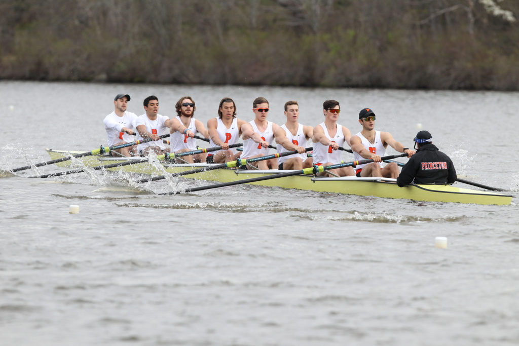 A group of people rowing a boat in a body of water