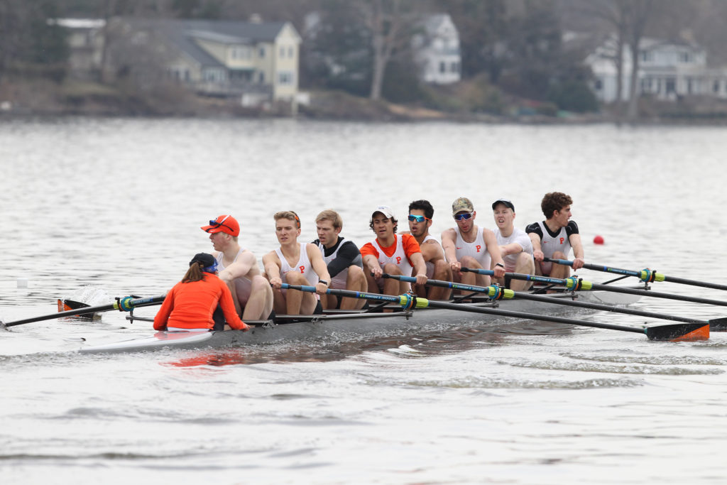 A group of people rowing a boat in the water