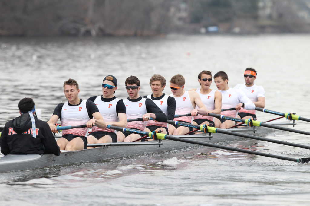 A group of people rowing a boat in the water