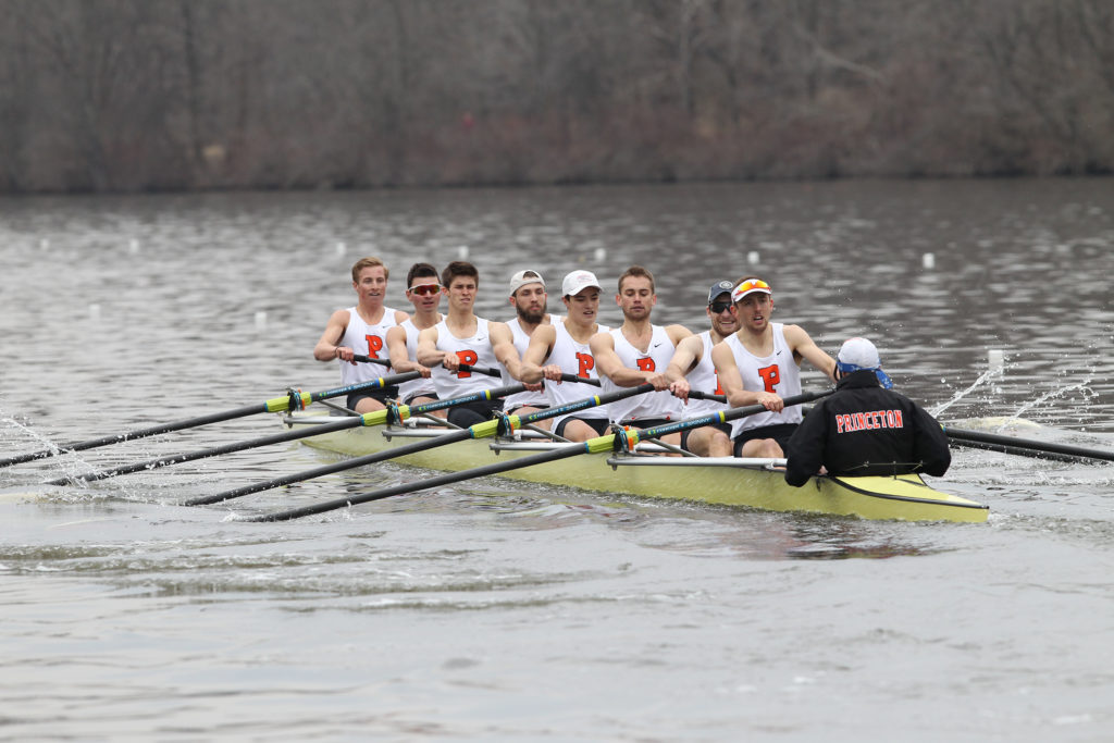 A group of people rowing a boat in a body of water