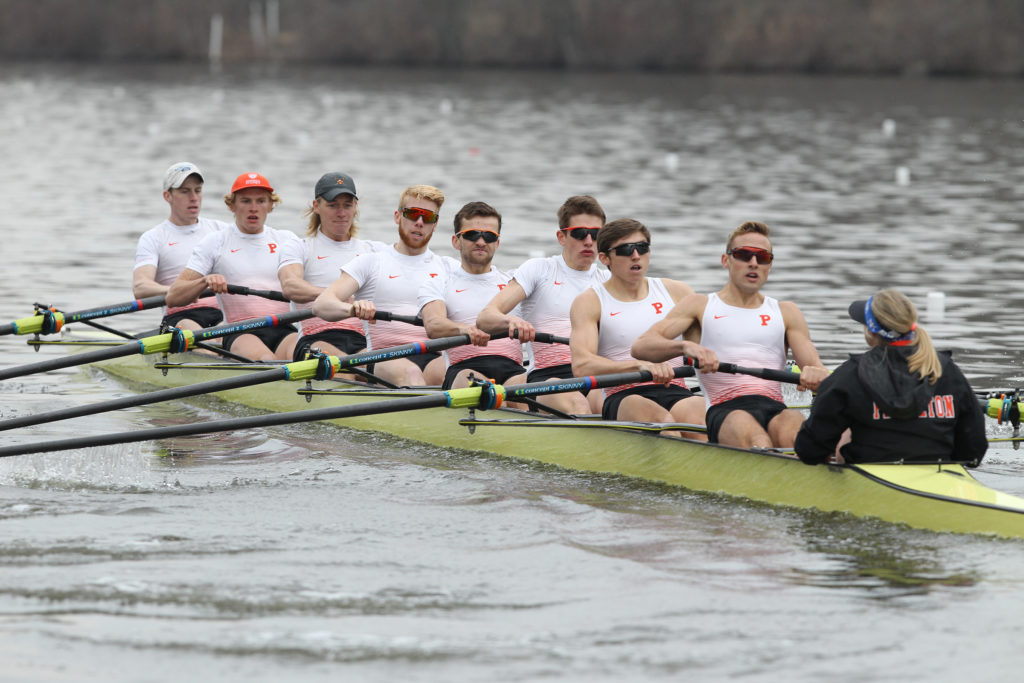 A group of people rowing a boat in a body of water