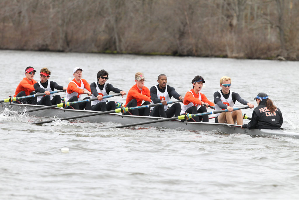 A group of people rowing a boat in the water