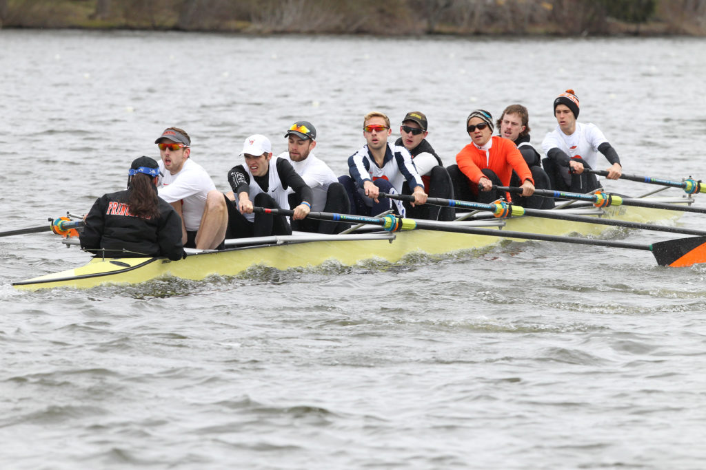 A group of people rowing a boat in the water