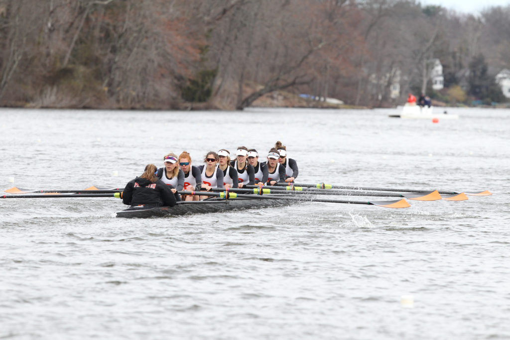 A group of people rowing a boat in the water