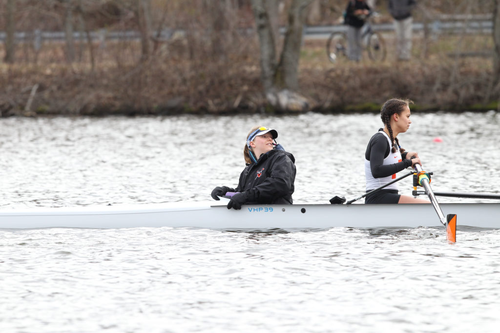 A group of people rowing a boat in the water