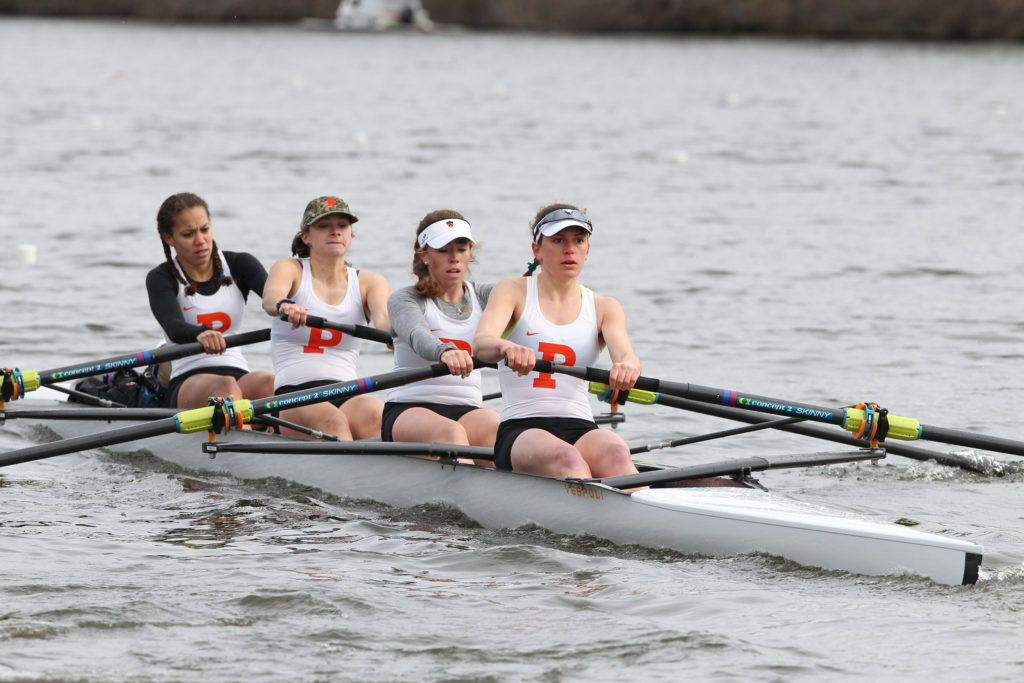 A group of people rowing a boat in a body of water