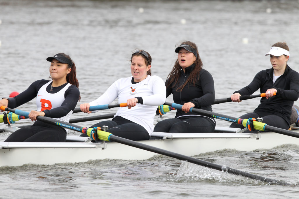 A group of people rowing a boat in the water