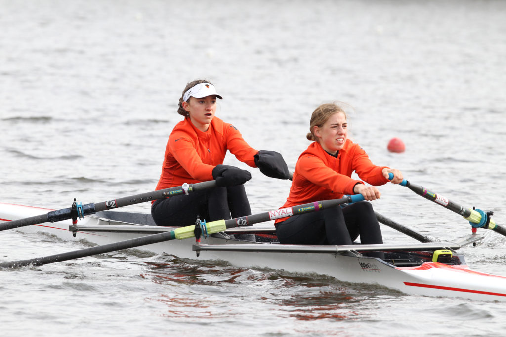 A group of people rowing a boat in the water