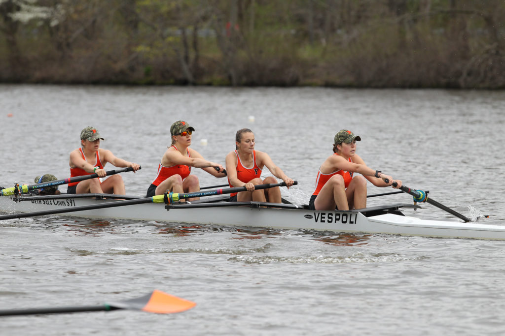 A group of people rowing a boat in the water