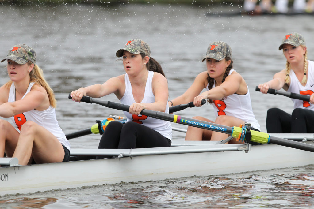 A group of people rowing a boat in the water