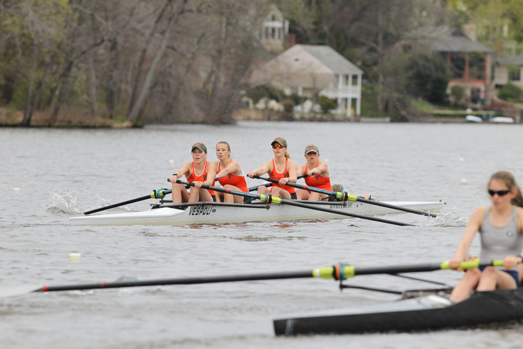 A group of people rowing a boat in the water