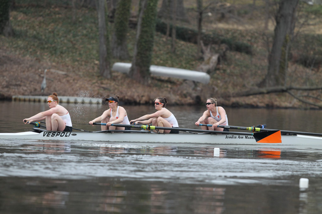 A group of people rowing a boat in the water