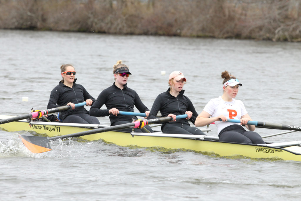 A group of people rowing a boat in a body of water