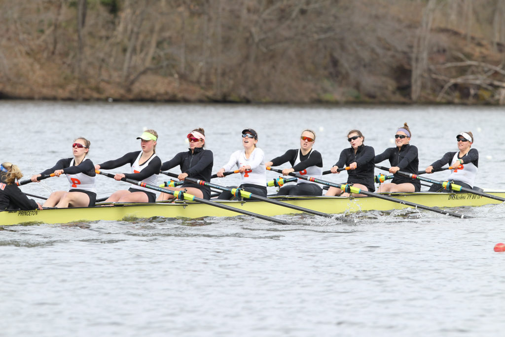 A group of people rowing a boat in a body of water