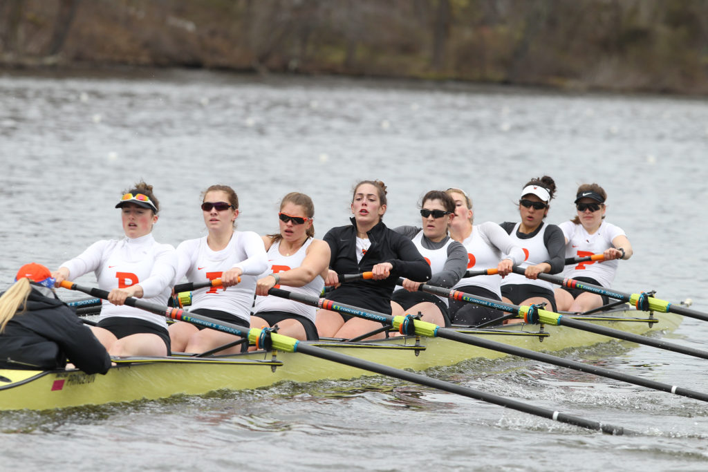 A group of people rowing a boat in the water