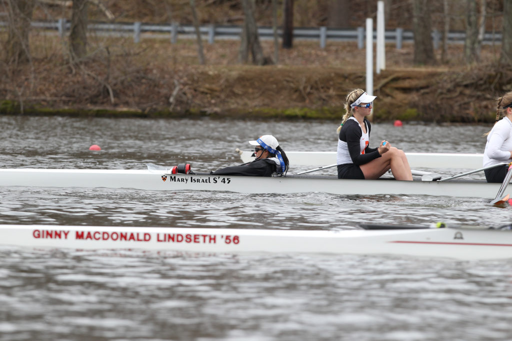 A group of people rowing a boat in the water