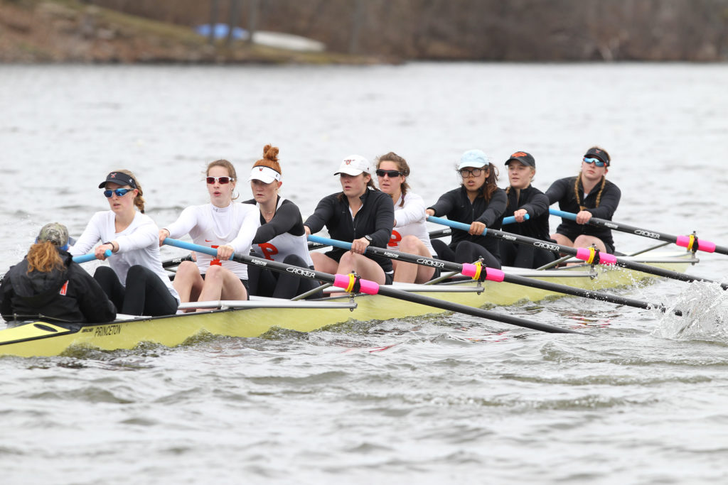 A group of people rowing a boat in a body of water